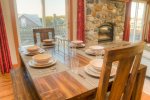 Have a family style meal at this dinner table with ocean views, near the fire place.